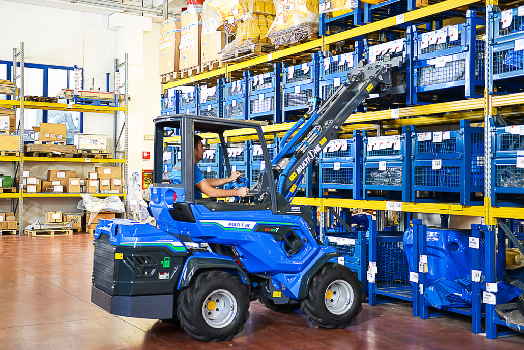 man using a mini loader EZ series with pallet fork