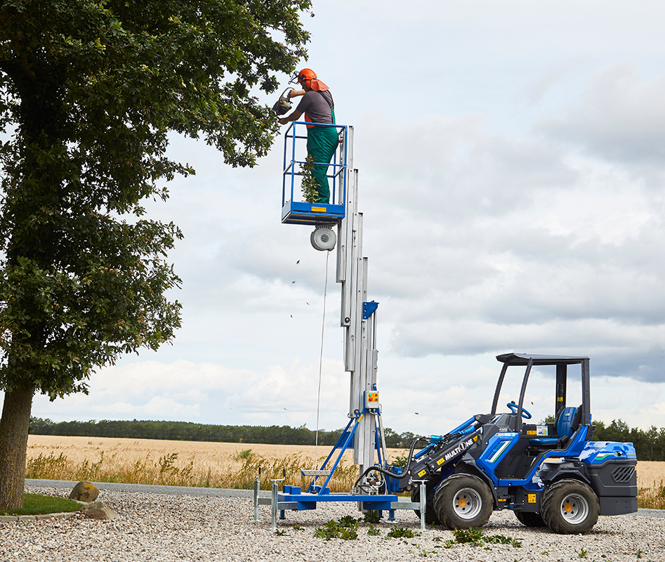 man trimming a tree on an aerial platform