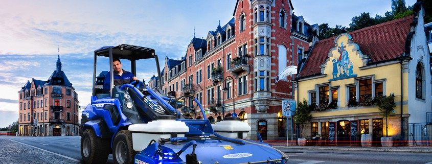 MultiOne mini loader 7 series with sweeper on a city street