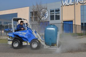 man cleaning the street in front on MultiOne venue with a street washer