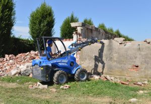 hydraulic breaker tearing down a wall seen from afar