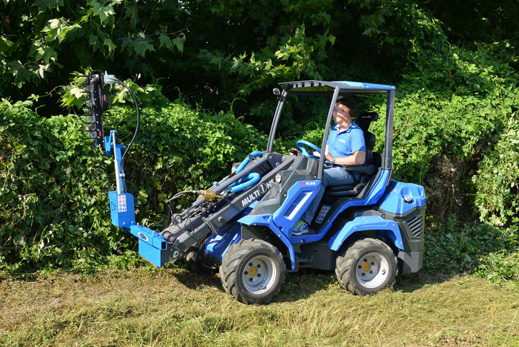 hedge trimmer cutting hedges, seen from left side