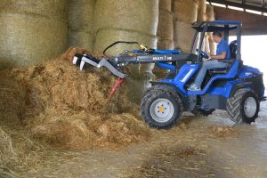 detail of a silage fork moving hay